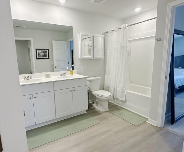 ensuite bathroom with wood finished floors, a sink, visible vents, and shower / bathtub combination with curtain