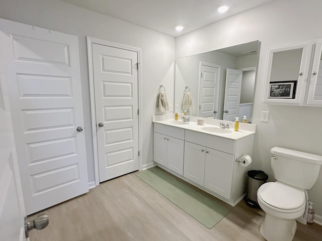 bathroom with hardwood / wood-style flooring, vanity, and toilet