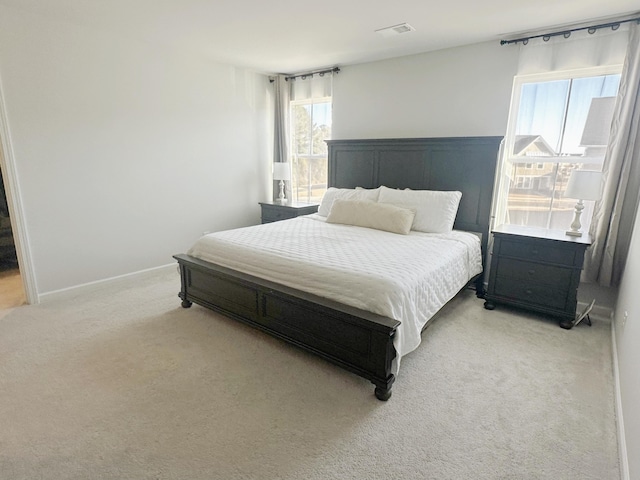 bedroom featuring light carpet, baseboards, and visible vents