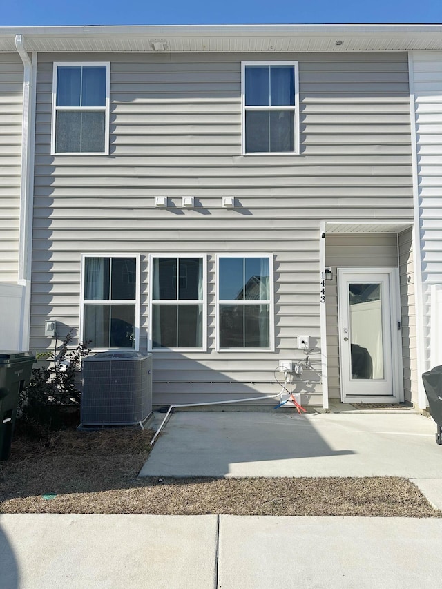 back of property with cooling unit and a patio