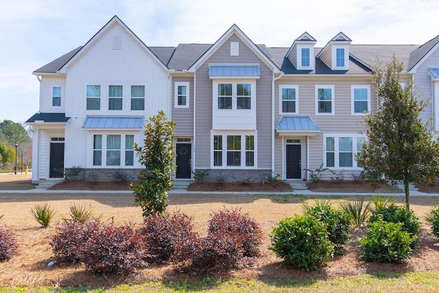 townhome / multi-family property featuring entry steps, metal roof, and a standing seam roof