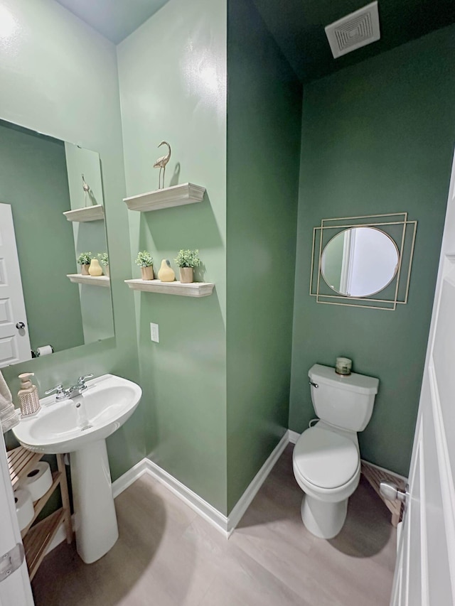 bathroom with wood-type flooring and toilet