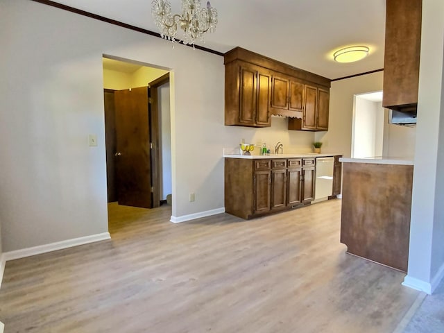 kitchen featuring dishwasher, ornamental molding, a notable chandelier, and light hardwood / wood-style flooring