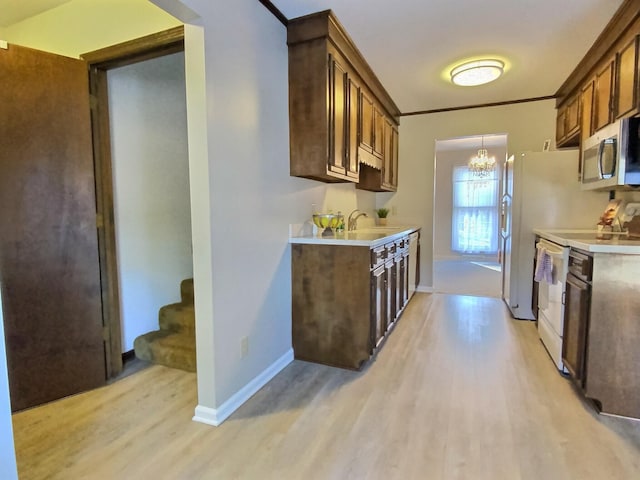 kitchen with sink, crown molding, an inviting chandelier, light hardwood / wood-style flooring, and electric stove