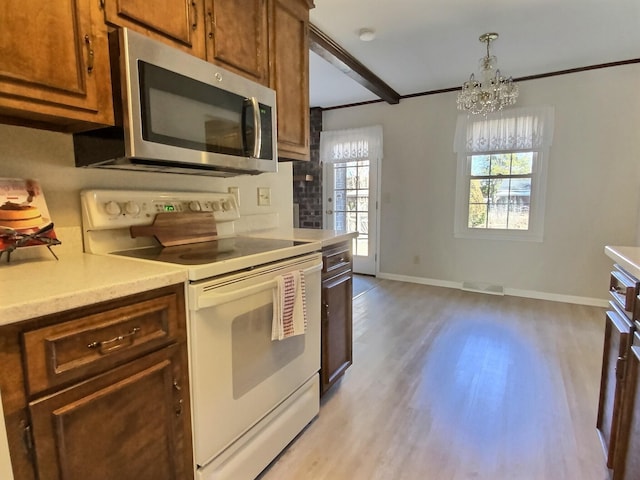 kitchen featuring decorative light fixtures, ornamental molding, white electric stove, a notable chandelier, and light hardwood / wood-style floors