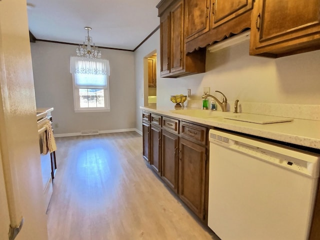 kitchen with sink, crown molding, hanging light fixtures, white dishwasher, and light wood-type flooring