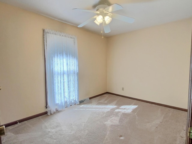 empty room with ceiling fan and light carpet