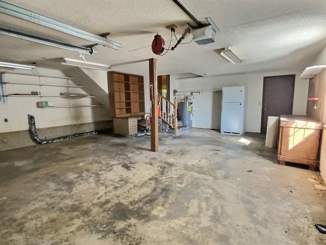 garage with a garage door opener, white fridge, and electric water heater