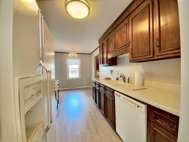 kitchen with sink, decorative light fixtures, ornamental molding, white appliances, and light hardwood / wood-style floors