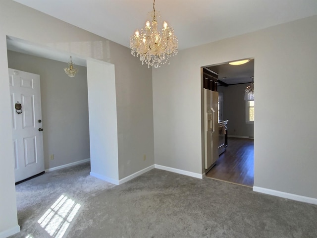 unfurnished room featuring dark carpet and an inviting chandelier