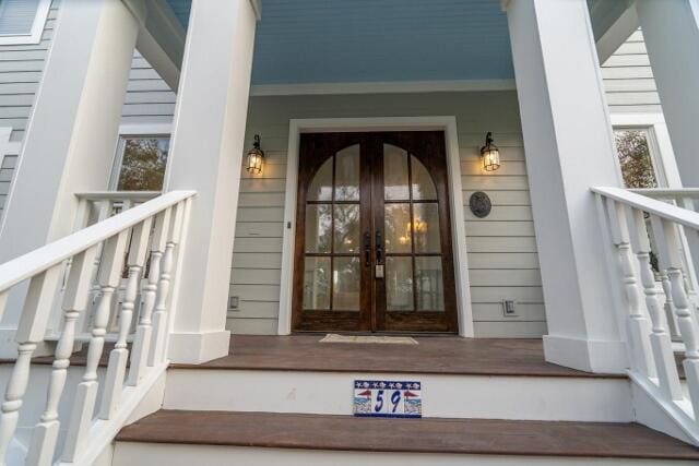 doorway to property featuring a porch and french doors