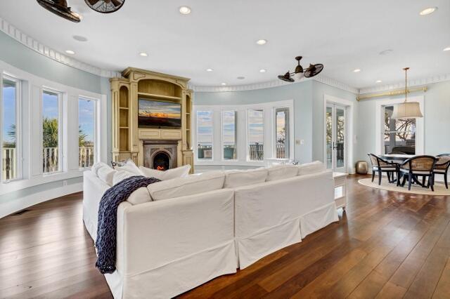 living room featuring a wealth of natural light, ceiling fan, dark wood-type flooring, and ornamental molding