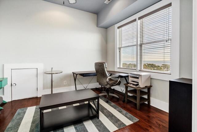 office space with plenty of natural light and dark hardwood / wood-style floors