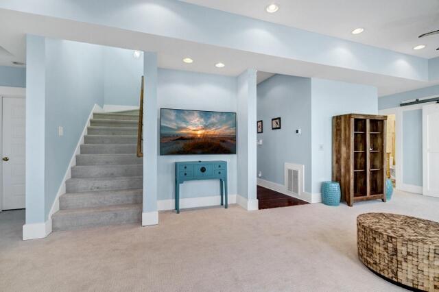 living room with carpet and a barn door