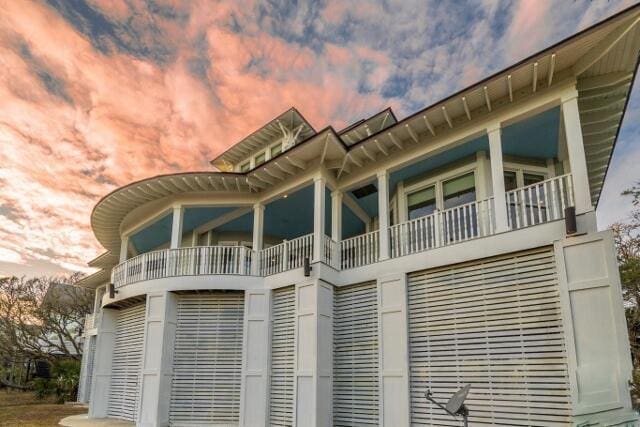 back house at dusk with a balcony