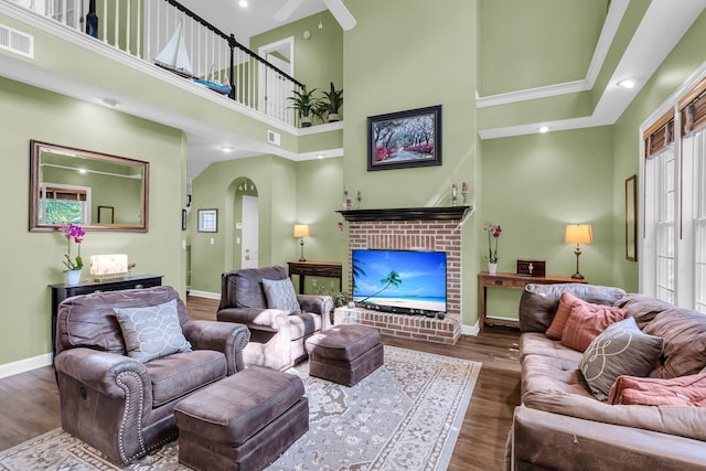 1311 Royal Links Dr, Mount Pleasant, SC 29466 - living area featuring arched walkways, a high ceiling, wood finished floors, a brick fireplace, and a ceiling fan