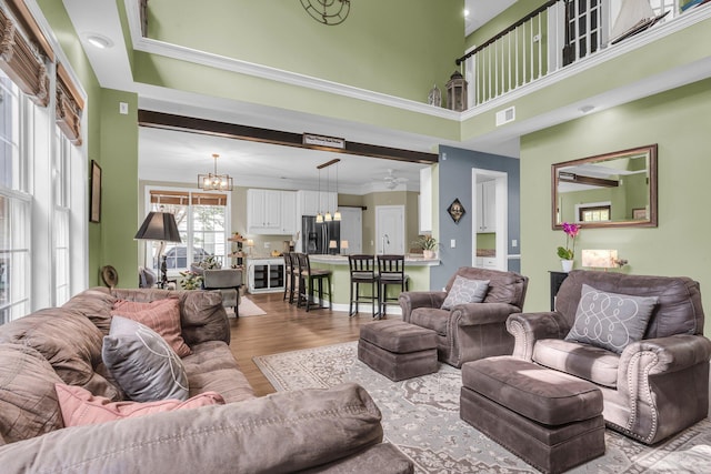 1311 Royal Links Dr, Mount Pleasant, SC 29466 - living area featuring a chandelier, light wood finished floors, ornamental molding, and a high ceiling