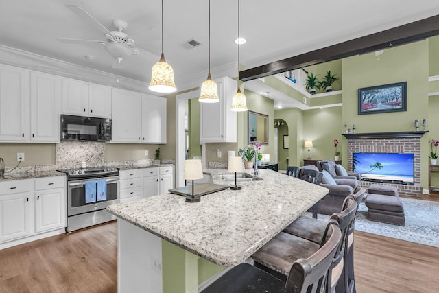 1311 Royal Links Dr, Mount Pleasant, SC 29466 - kitchen featuring black microwave, stainless steel electric range, white cabinetry, and ornamental molding