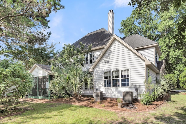 1311 Royal Links Dr, Mount Pleasant, SC 29466 - rear view of property with a sunroom, a lawn, a chimney, and roof with shingles