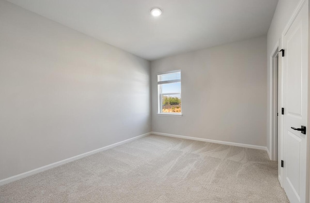 unfurnished room with baseboards and light carpet