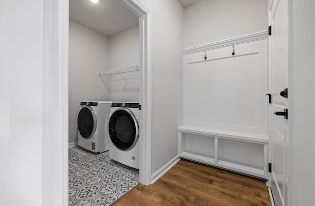 washroom with baseboards, wood finished floors, laundry area, and washing machine and clothes dryer