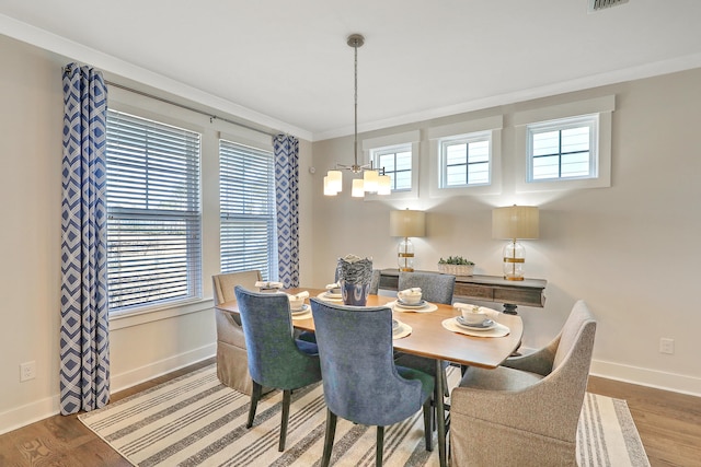 dining area with plenty of natural light, an inviting chandelier, and wood finished floors