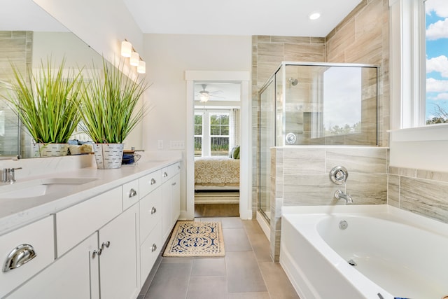 ensuite bathroom with tile patterned flooring, a stall shower, a garden tub, and a sink