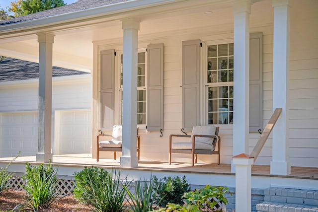 entrance to property with a garage, covered porch, and roof with shingles