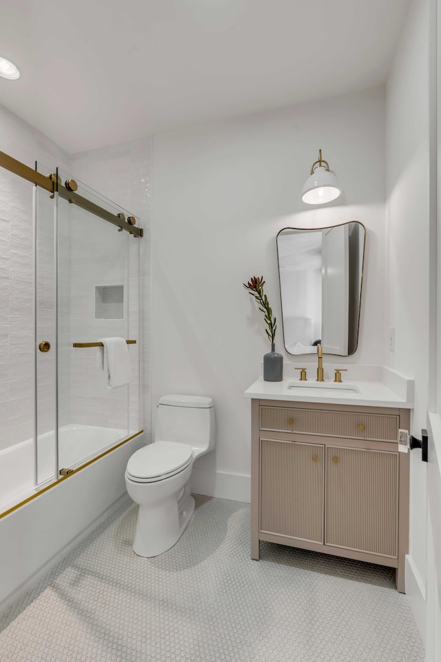 full bathroom featuring bath / shower combo with glass door, toilet, vanity, baseboards, and tile patterned floors