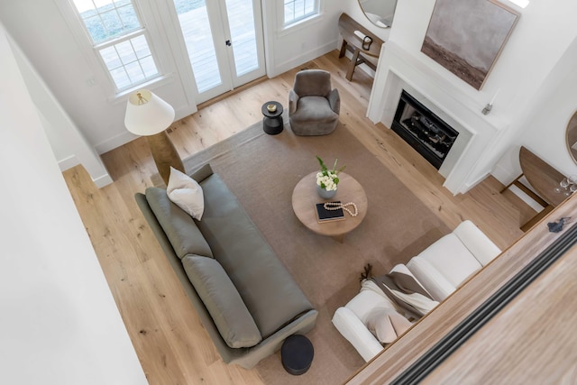 living room with a fireplace, baseboards, and wood finished floors