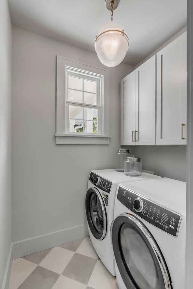 clothes washing area with light floors, baseboards, cabinet space, and washing machine and clothes dryer