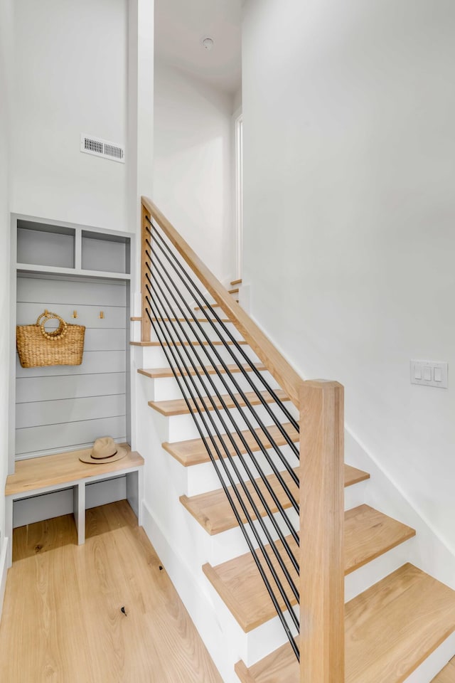 stairway with wood finished floors and visible vents