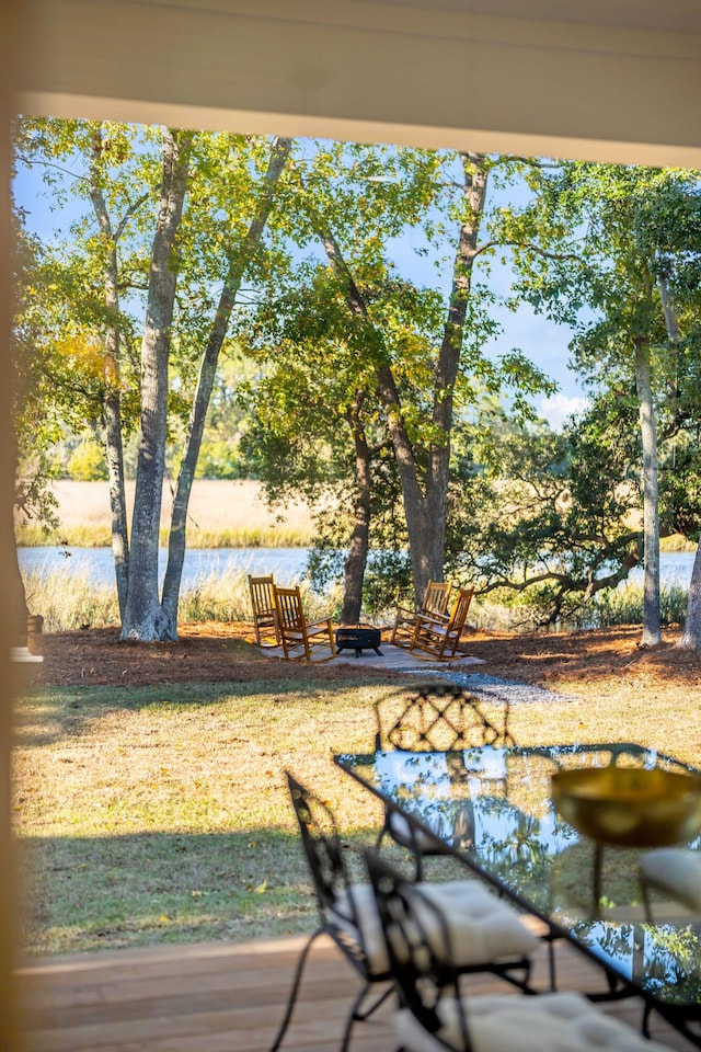 exterior space featuring a water view, a patio, and a fire pit