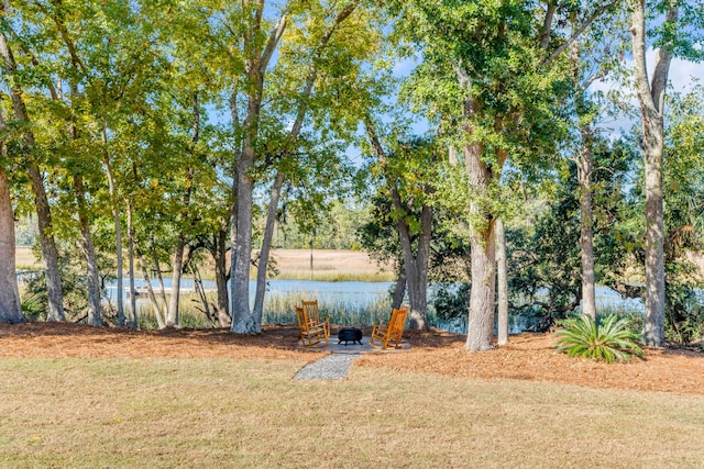 view of yard with an outdoor fire pit and a water view