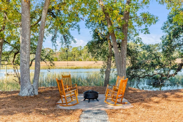 view of patio / terrace with a fire pit and a water view