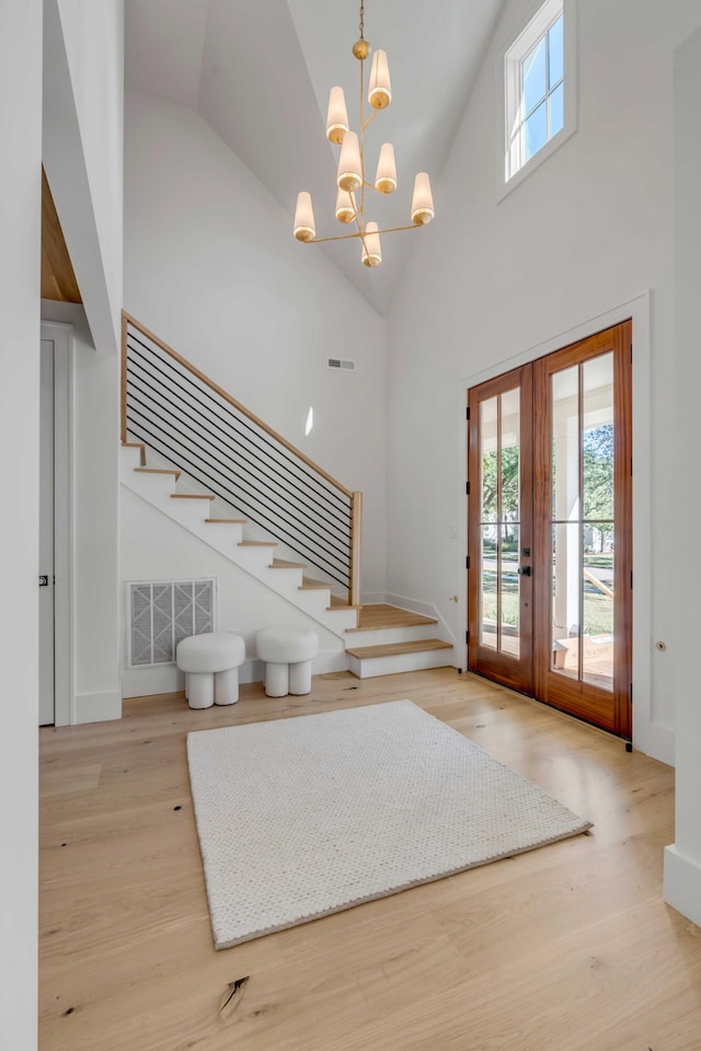 foyer with french doors, visible vents, stairway, and wood finished floors