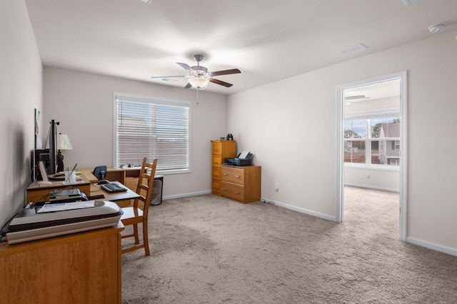 office space featuring light carpet, ceiling fan, and a healthy amount of sunlight