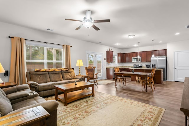 living room with hardwood / wood-style floors, ceiling fan, and a wealth of natural light