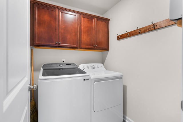 clothes washing area with cabinets and independent washer and dryer