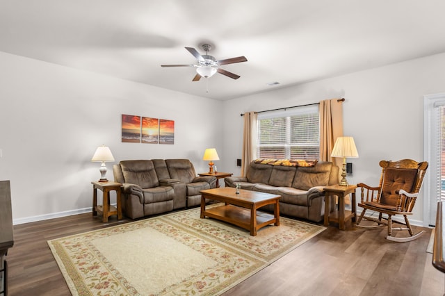 living room featuring ceiling fan and dark wood-type flooring