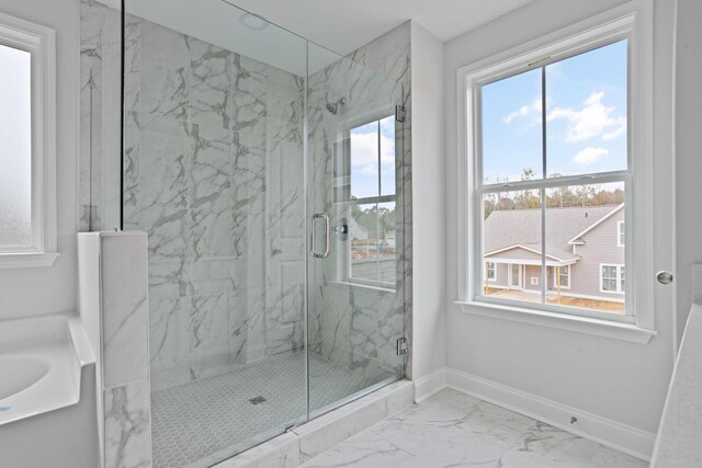 bathroom featuring a marble finish shower, marble finish floor, a garden tub, and baseboards