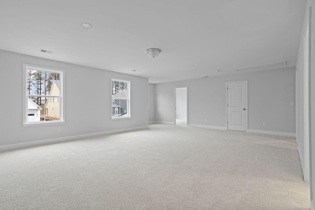 spare room with visible vents, light colored carpet, and baseboards