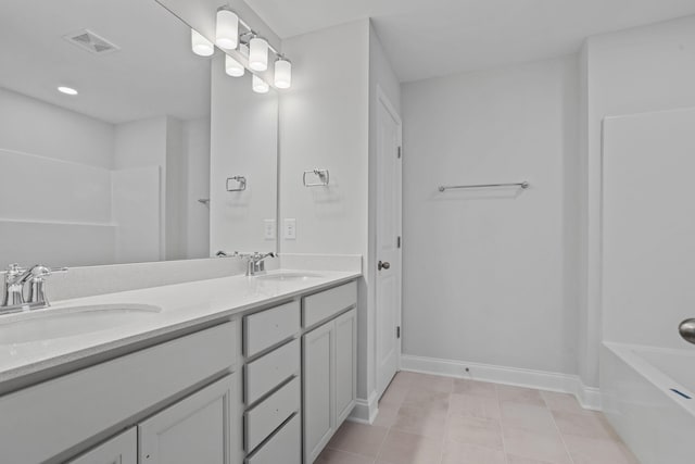 full bathroom with double vanity, visible vents, baseboards, and a sink