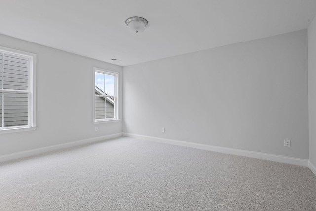 carpeted empty room featuring visible vents and baseboards