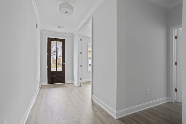 foyer entrance featuring visible vents, crown molding, baseboards, and wood finished floors