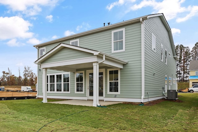 rear view of house featuring cooling unit, a lawn, and a patio area