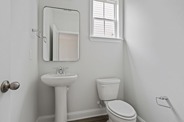 bathroom with a sink, baseboards, toilet, and wood finished floors