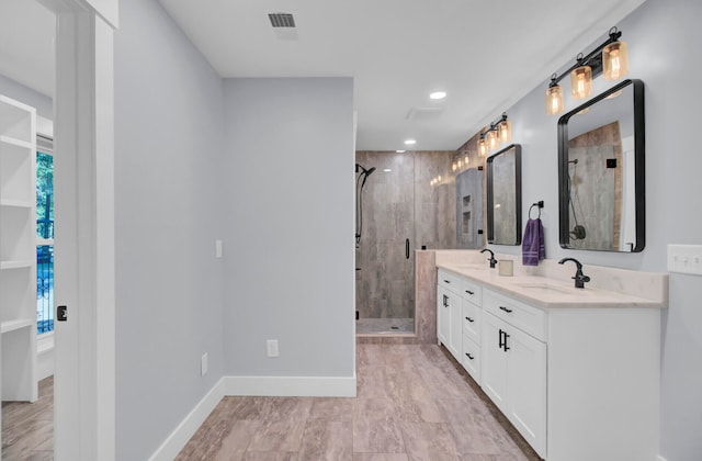 bathroom with a shower with door and vanity