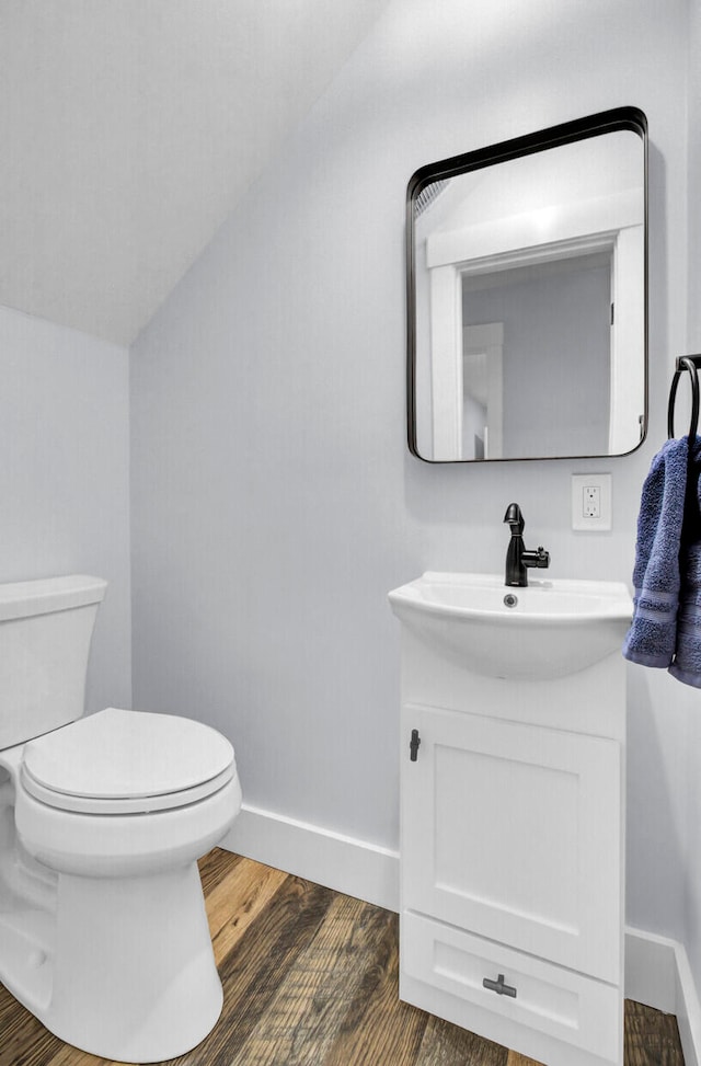 bathroom with toilet, hardwood / wood-style floors, and vanity