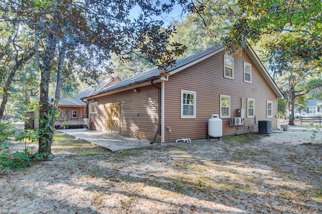 rear view of property featuring a patio and central AC